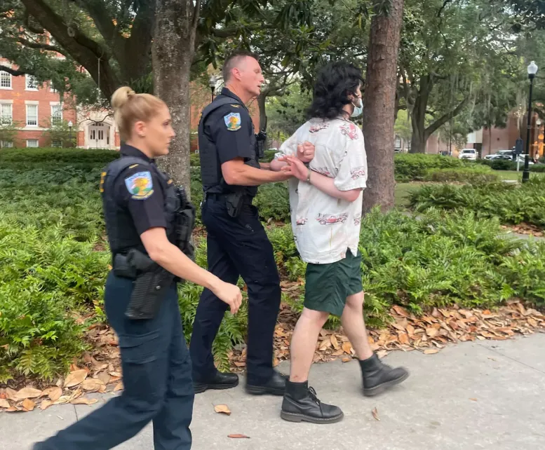 Frasheri being led away by police officers